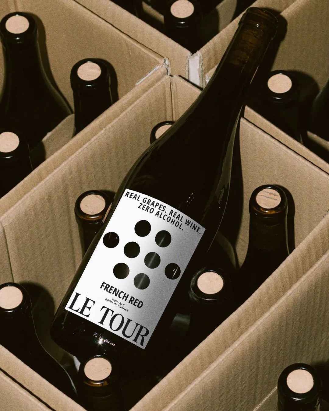 le-tour-non-alcoholic-french-red-wine-bottle-nestled-among-other-bottles-in-cardboard-box-packaging